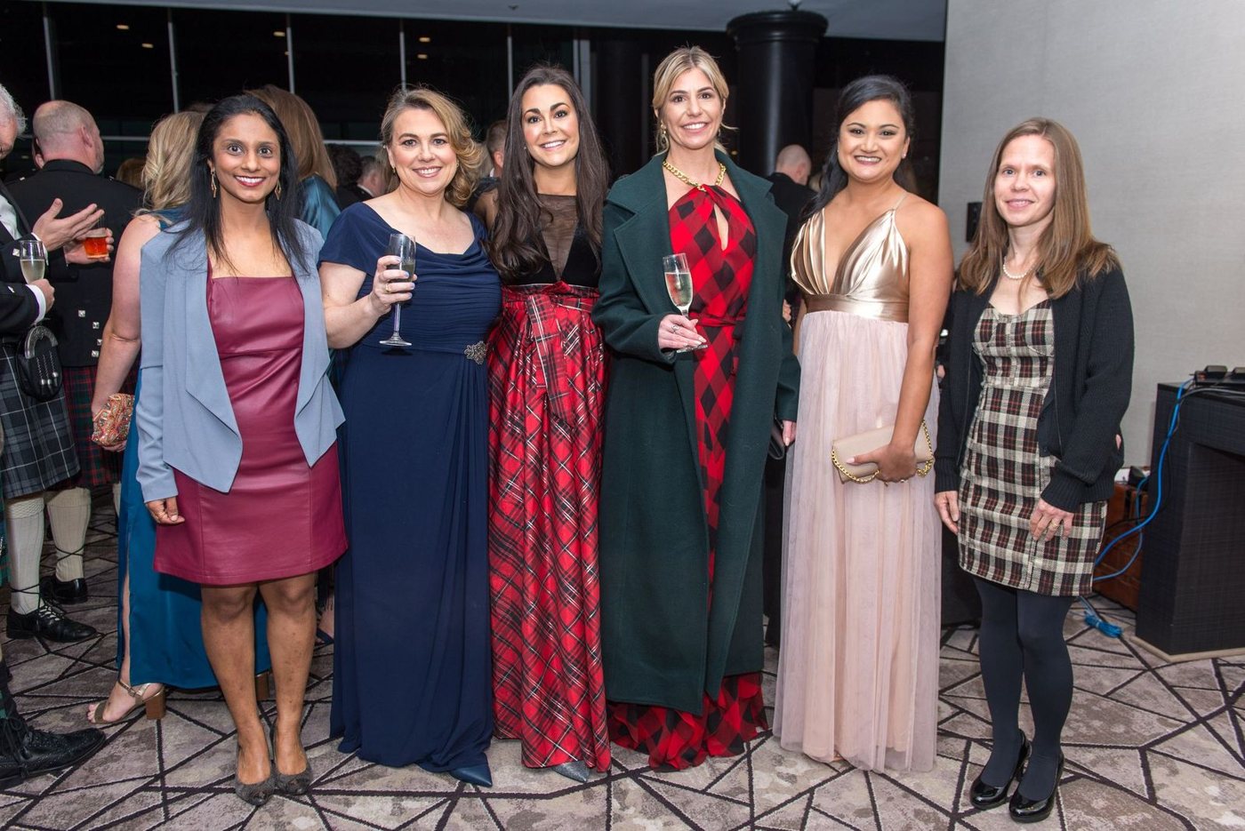 A group of guests in evening gowns and tartan at the supper